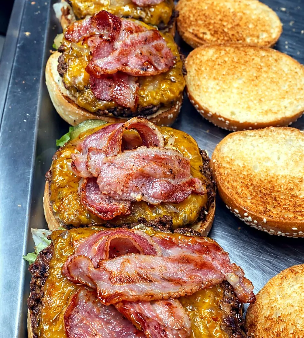 Rangée de burgers au bacon et cheddar en préparation